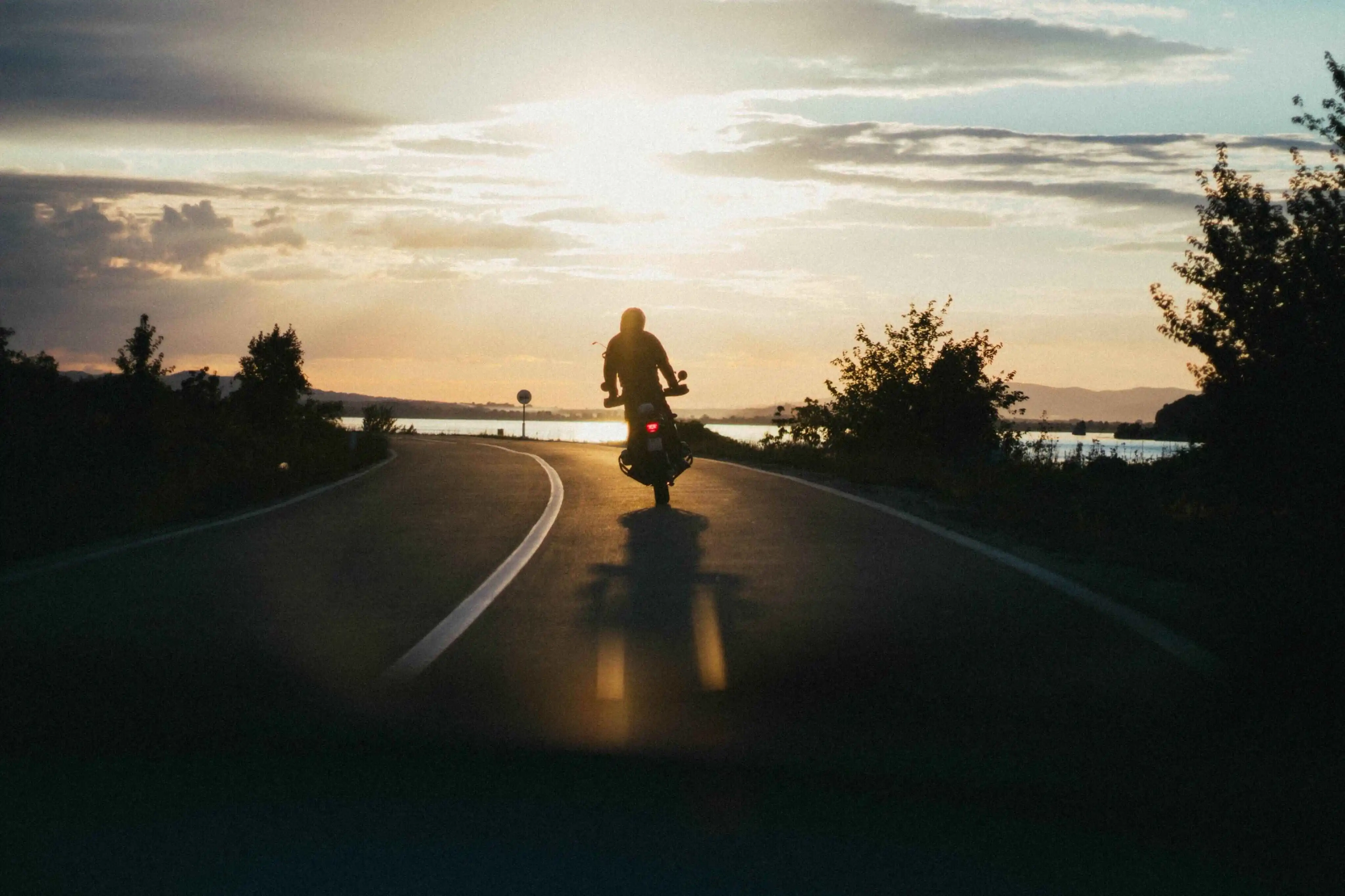 Motorista disfrutando puesta de sol en su ruta